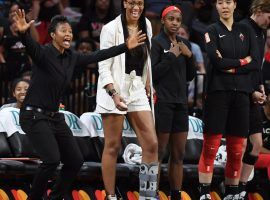 An injury Aâ€™ja Wilson watches the Las Vegas Aces from the bench with assistant coach Vickie Johnson (left) and teammates Jackie Young and JiSu Park (right). (Image: Ethan Miller/Getty)