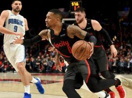 Portland Trailblazersâ€™ Damian Lillard drives by Orlando Magic center Nikola Vucevic (9). (Image: Steve Dykes/AP)