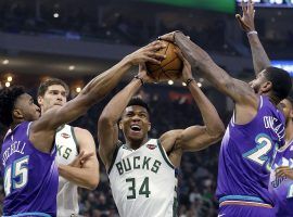 Milwaukee Bucks star Giannis 'Greek Freak' Antetokounmpo (34) drives to the hole against Donovan Mitchell (45) and Royce O'Neale (23) of the Utah Jazz. (Image: Aaron Gash/AP)