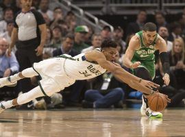 Giannis "Greek Freak" Antetokounmpo of the Milwaukee Bucks dives for a loose ball against the Boston Celtics' Jayson Tatum in Milwaukee, WI. (Image: Jeff Hanisch/USA Today Sports)