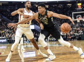 Milwaukee’s Giannis Antetokounmpo, on his way to a career-setting night, drives by rookie Mikal Bridges from the Phoenix Suns. (Image: Reuters)