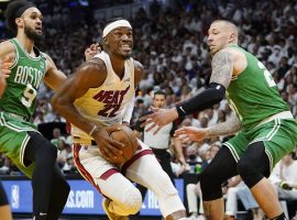 Jimmy Butler from the Miami Heat powers through the late by splitting defenders Derricks White (9) and Daniel Theis (27). (Image: Getty)