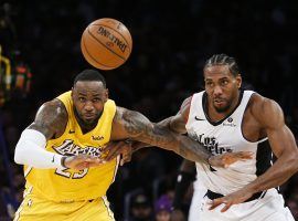 LeBron James (left) and Kawhi Leonard fight for a loose ball at Staples Center. (Image: Ringo H.W. Chiu/AP)