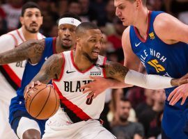 Damian Lillard of the Portland Blazers drives by Denver Nuggets center Nikola Jokic during a playoff game in Portland, Oregon. (Image: Porter Lambert/Getty)