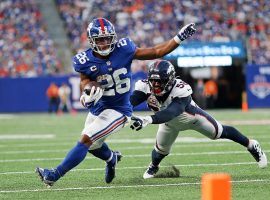 Saquon Barkley from the New York Giants tries to evade a tackle from the Denver Broncos in 2021 (Image: Getty)