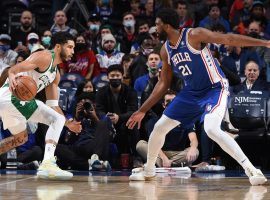 Jayson Tatum from the Boston Celtics is defended by Joel Embiid of the Philadelphia 76ers, but both teams are in a tough fight for the Atlantic Division title.