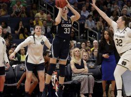 UCONNâ€™s Katie Lou Samuelson shoots a three-point shot while Notre Dameâ€™s Jessica Shepherd tries to defend during a Womenâ€™s Final Four game in Tampa, FL. (Image: Chris Oâ€™Meara/AP)