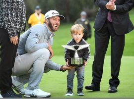 Dustin Johnson poses with his son and the trophy he won last year at the Genesis Open. He is a 5/1 pick to defend his title. (Image: LA Times)