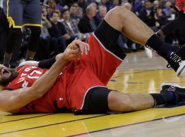 Toronto Raptors' center Jonas Valanciunas withers in pain after a hack job from the Golden State Warriors' Draymond Green. (Image: Jeff Chiu/AP)