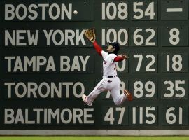 Boston Red Sox outfielder Andrew Benintendi leaps to make a catch in front of the Green Monster in the fifth inning of Game 2 of the 2018 World Series against the Los Angeles Dodgers. (Jim Davis/Boston Globe)