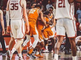 Texas players mob Matt Coleman after he hit a game-winning 3-pointer at the buzzer to loft Texas over Oklahoma in Austin. (Image: Texas Athletics)