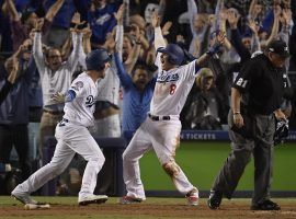 Manny Machado (right) celebrates with Yasmani Grandal (left) after scoring the winning run in the Los Angeles Dodgers’ 2-1 victory over the Milwaukee Brewers in Game 4 of the 2018 NLCS. (Image: Mark J. Terrill/AP)