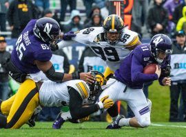 The Northwestern Wildcats QB Aidan Smith is tackled by the Iowa Hawkeyes. (Image: Daniel Bartel/Getty)