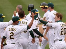 Mark Canha (20) is congratulated by his Oakland A's teammates after a walk-off hit to win in extra innings. (Image: Ezra Shaw/Getty)