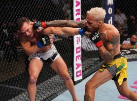 Charles Oliveira (right) punches Michael Chandler (left) on his way to winning the lightweight title in the main event of UFC 262 on Saturday, May 15, 2021. (Image: Josh Hedges/Zuffa)