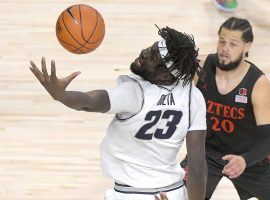 Utah State center Neemias Queta lunges for the ball, while San Diego State guard Jordan Schake looks on during a meeting between the top two teams in the Mountain West. (Image: Eli Lucero/AP)